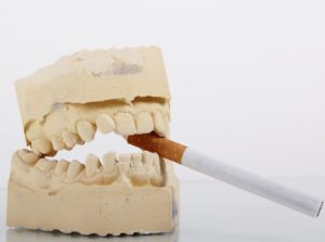 cigareta v zubech lebky. Kdo kouří umírá pomalu a bolestně