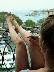 Mladá žena na balkoně si užívá mořský vzduch vypraný vodou Hyla